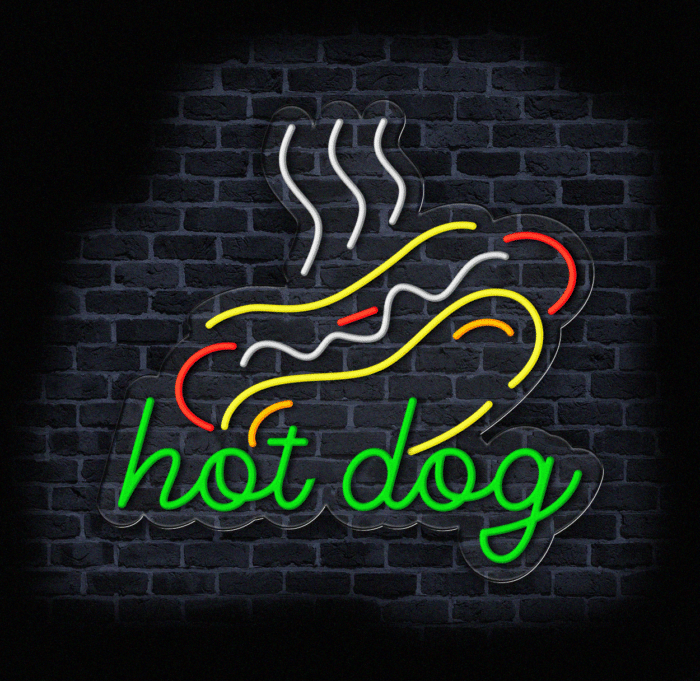 Neon LED przedstawiający hot doga w kolorach zielonym, żółtym, czerwonym i białym na tle ceglanej ściany