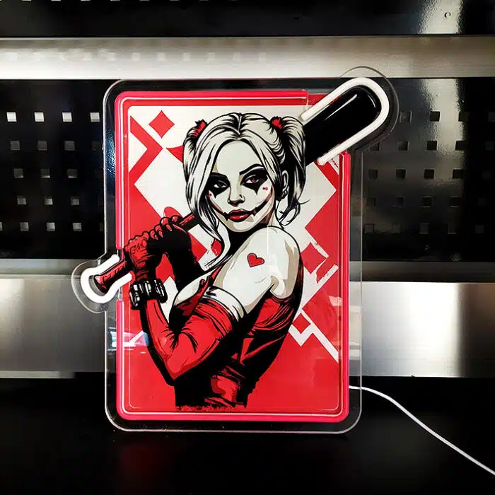 Podświetlony neon LED przedstawiający postać kobiety z kijem bejsbolowym na tle czerwonych wzorów.