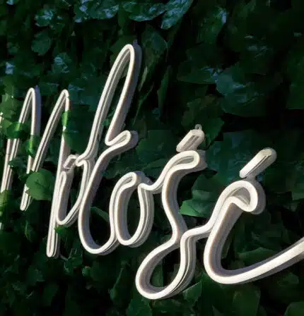 Neonowy napis „Miłość” na wesele – idealna dekoracja ślubna na tle zieleni